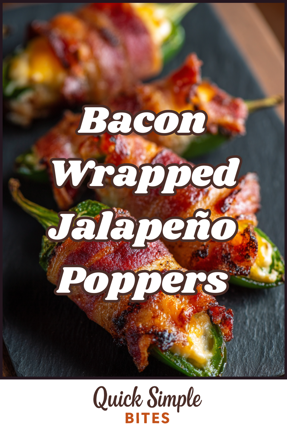Three Bacon-Wrapped Jalapeño Poppers filled with melted cheese are arranged on a slate tray. Text overlay reads “Bacon Wrapped Jalapeño Poppers.”.